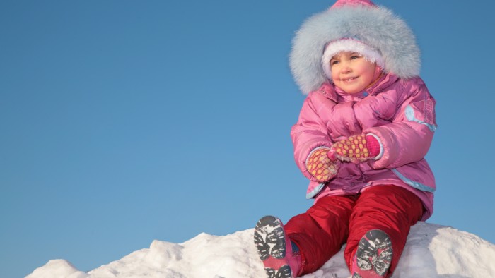 child sit on snow hill on blue sky background 2